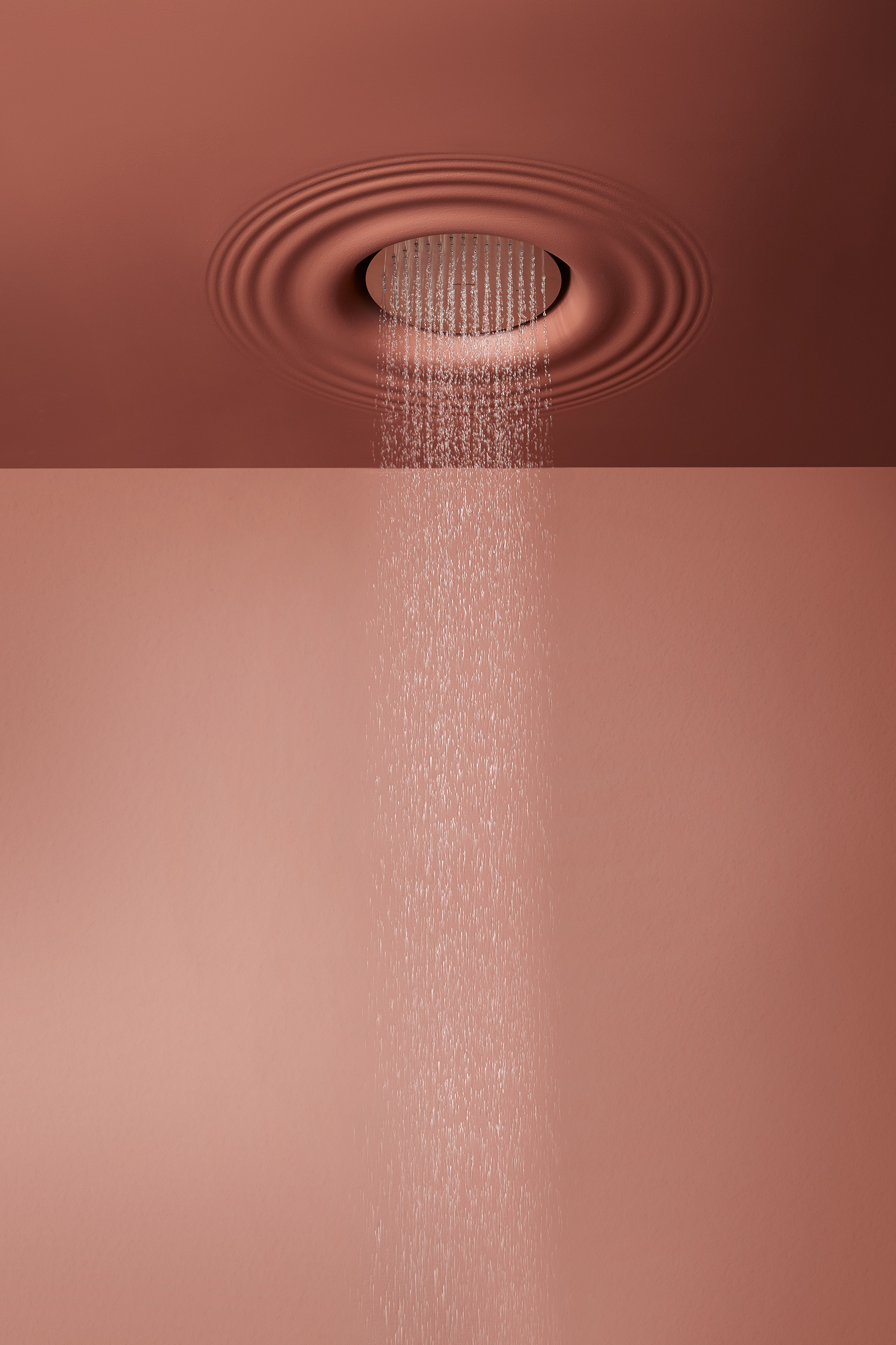 it is a showerhead integrated in the ceiling that reproduces the image of the effect generated by a drop of rain that hits the surface of the water.